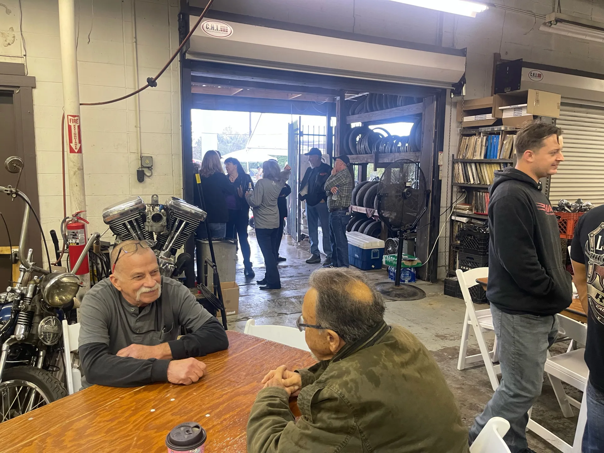 Inside the McCreations shop on Hwy 249 — vintage Harley engine, riders gathered at tables